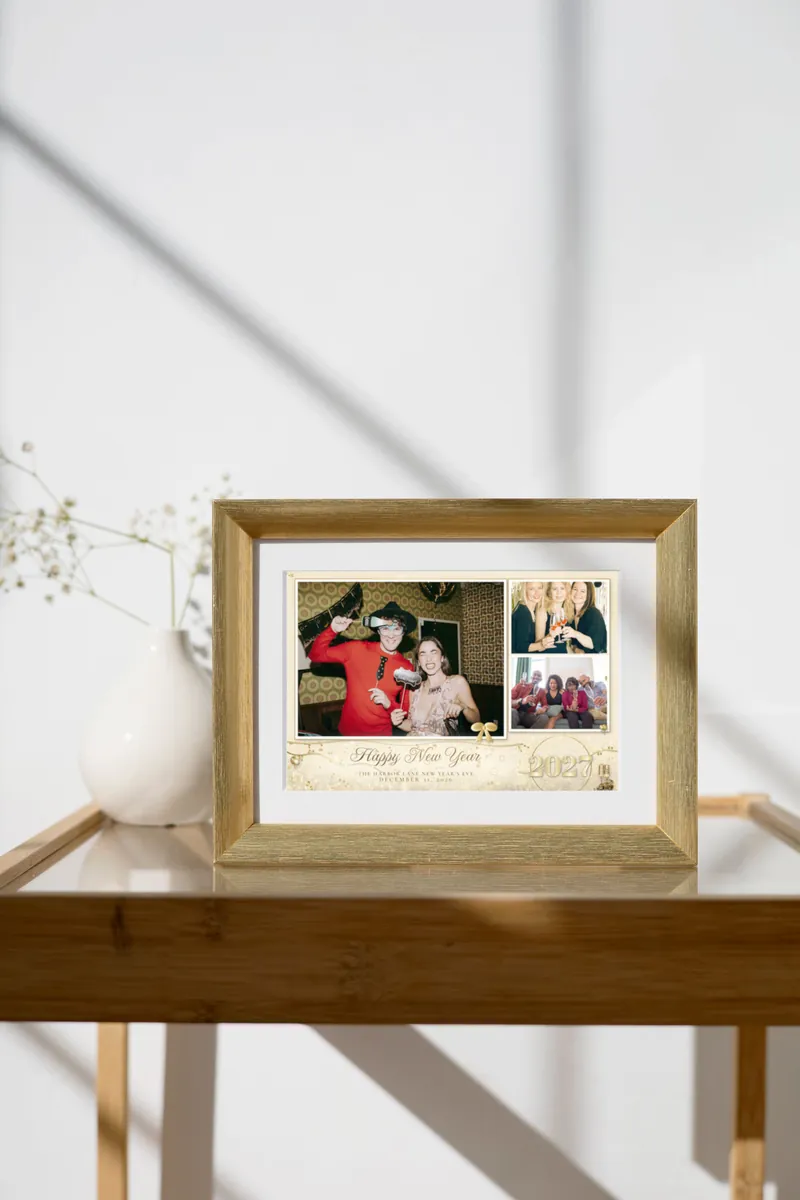 The Champagne Toast New Year's Eve 4x6 print in a gold frame on a glass console