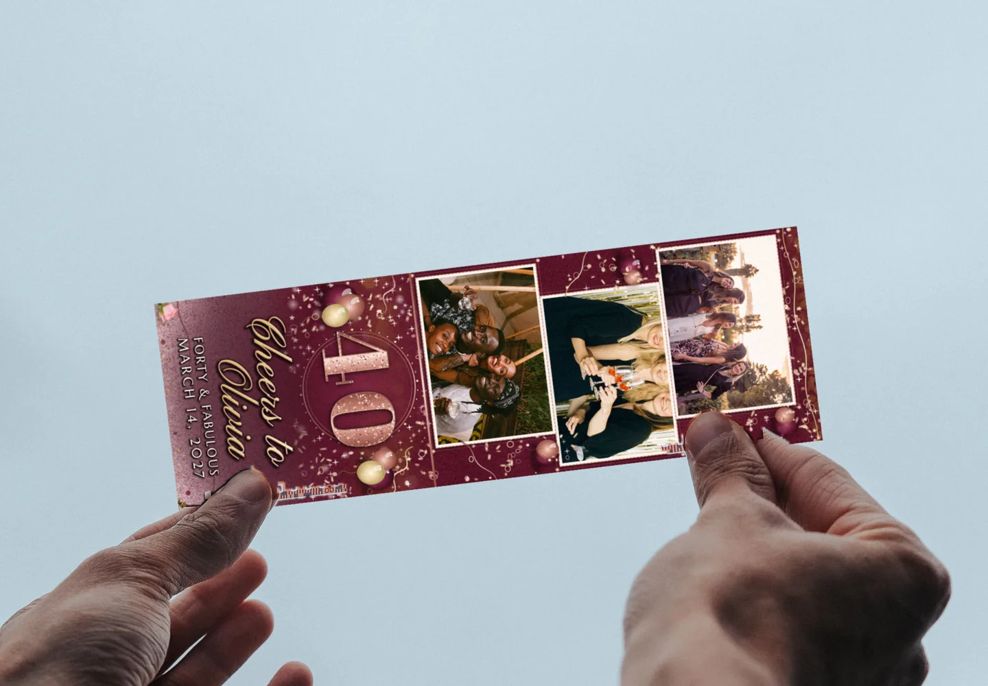 A Rose Gold Forty 2x6 photo strip held up to the sky in two hands